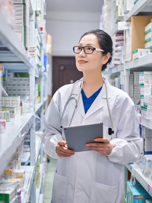 Doctor looking over shelf of prescription drugs